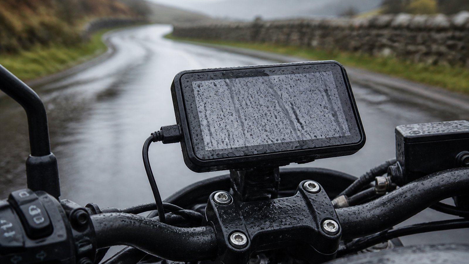Rain-beaded motorcycle navigation display on wet UK bars